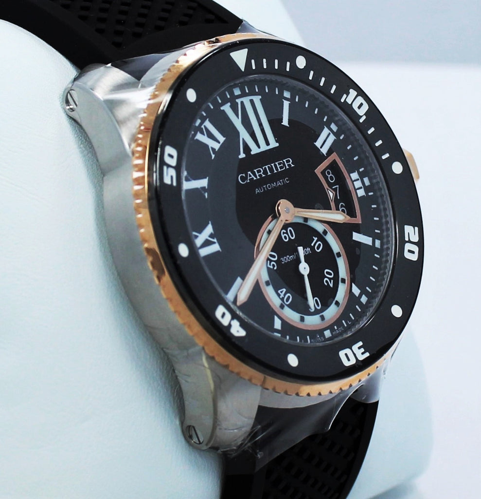 Cartier Calibre De Cartier Diver W7100055 42mm Automatic 18K Rose Gold *UNWORN* Details:   Make: Cartier Model: W7100055 Calibre Condition: Unworn  Includes: The Boxes & Papers  Movement: Automatic Material: Stainless Steel 18K Rose Gold Case Size: 42mm Crystal: Sapphire Crystal  Dial: Roman Numeral Black Dial Bezel:  Cartier Factory 18K Rose Gold Diamond Bezel  Bracelet:  Cartier Black Rubber Band Clasp: Tang Buckle  Crown : 18kt rose gold crown with a flush-mounted blue spinel cabochon.  
